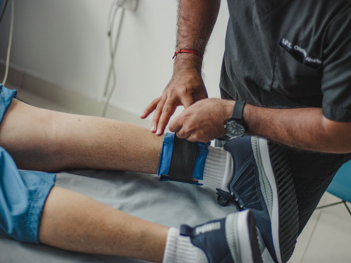 An orthopaedic doctor fitting a support brace on a patient's leg